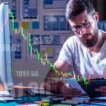 corma- A man sitting at his desk analyzing a stock chart.